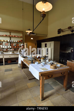 Victorian Kitchen with woman dressed as Victorian Kitchen maid. Stock Photo