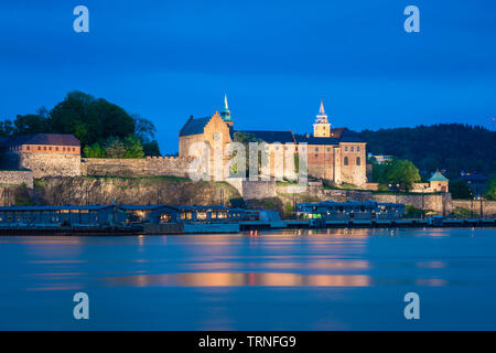 Akershus Oslo, view at night across Oslo fjord towards the Akershus Festning (fortress) complex sited in the city harbour, Oslo, Norway. Stock Photo