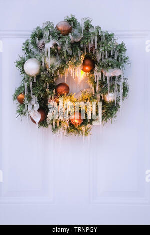 Close-up of a ice covered Christmas wreath hung on a door in winter. Stock Photo