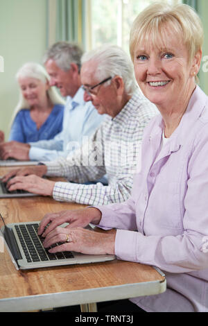 Portrait Of Senior Woman With Tutor In Computer Class Stock Photo