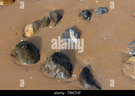 Rocks on the beach seashore in the sand and water. Quiet, peaceful concept. Stock Photo