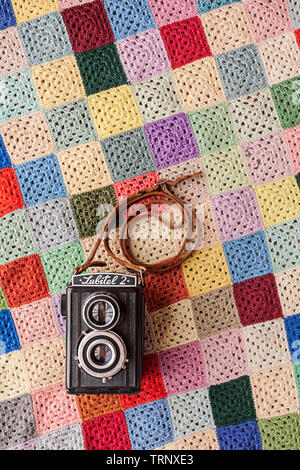 Vintage 1950's Russian twin-lens reflex 6x6 lubitel 2 film camera with leather strap on a retro background. Stock Photo