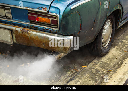 Vintage old car emits pollutant out of the exhaust Stock Photo