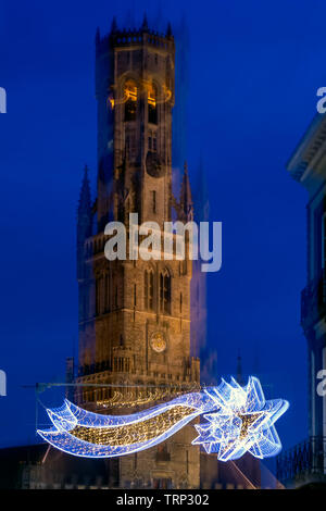 Abstract image of Belfry of Bruges with Christmas decoration in front. Intentional abstract motion blur effect. Stock Photo