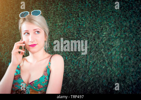 Young woman talking on mobile phone in garden Stock Photo
