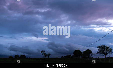 Tynygraig, Ceredigion, Wales, UK. 10th June, 2019. UK Weather: Colourful sky as the sun begins to set amongst the dark clouds this evening in Ceredigion, Mid Wales. Credit: Ian Jones/Alamy Live News Stock Photo