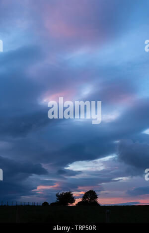 Tynygraig, Ceredigion, Wales, UK. 10th June, 2019. UK Weather: Colourful sky as the sun begins to set amongst the dark clouds this evening in Ceredigion, Mid Wales. Credit: Ian Jones/Alamy Live News Stock Photo