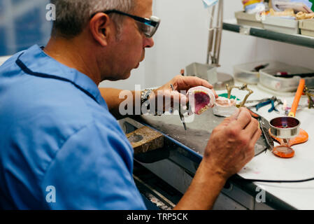 Caucasian man working on a dental prosthesis Stock Photo