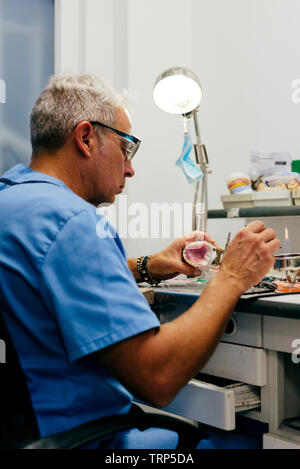 Caucasian man working on a dental prosthesis Stock Photo