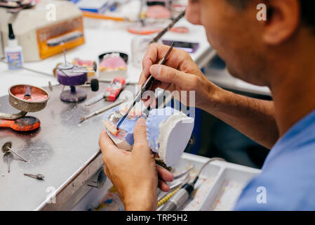 Caucasian man working on a dental prosthesis Stock Photo