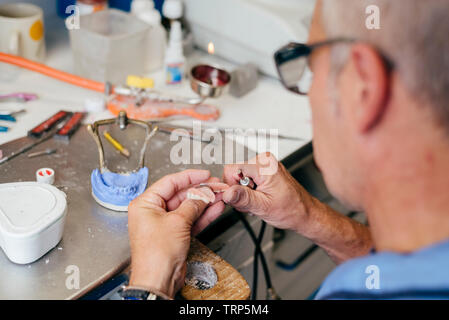Caucasian man working on a dental prosthesis Stock Photo