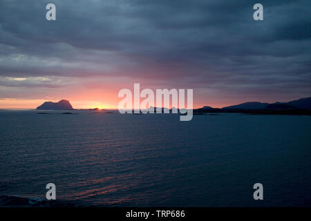 Sun setting over rocks sailing away from alesund,Norway Stock Photo