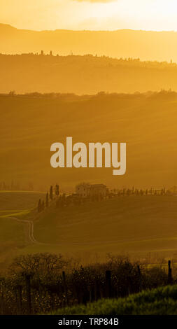 Fiery sunset over the hills of the Val d'Orcia in Tuscany, Italy, just in the outskirts of the town of Pienza Stock Photo