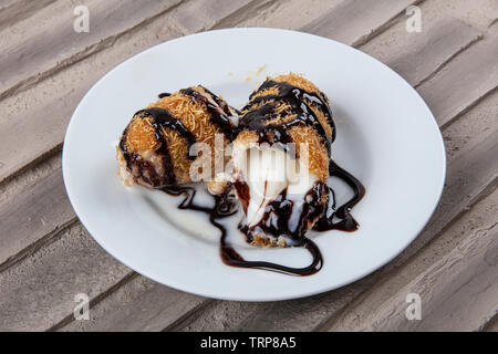 Delicious Turkish dessert. Fried ice-cream covered with chocolate Kadayif. Stock Photo