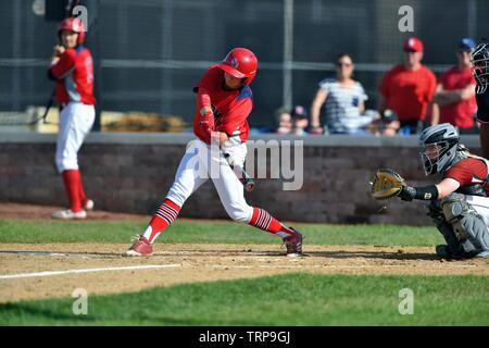 Baseball helmet, bat and ball on field at brightly lit outdoor stadium ...