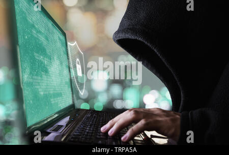 Digital data security system and protection. Anonymous hacker try to hacking on computer laptop Stock Photo