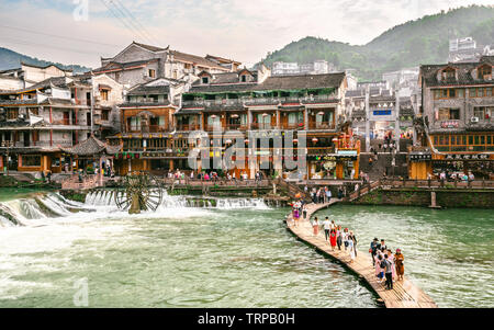 2 June 2019, Fenghuang China : Wooden makeshift bridge and Fenghuang panorama with lots of chinese tourists in phoenix ancient town in Hunan China Stock Photo