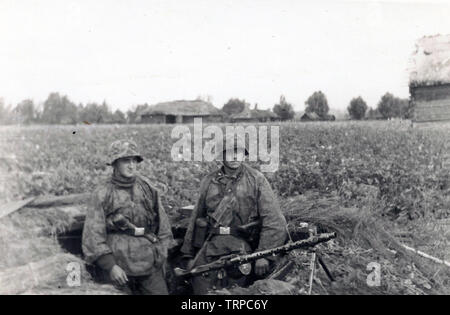 Two Waffen SS Men in camouflage Smocks from the 2nd SS Panzer Division Das Reich in a trench with a Light MG on the Russian Front 1941 Stock Photo