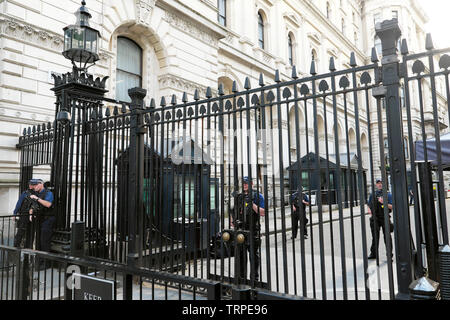 Guards with guns at the closed iron gates at the entrance of 10 Downing Street in the City of Westminster, Central London England UK  KATHY DEWITT Stock Photo