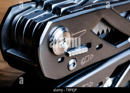 Macro image of a generic multitool at the hinged end of the handle. Stock Photo