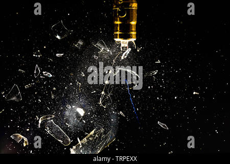 Sparking and exploding incandescent lightbulb.  The glass fragments are clear and distinct against a black background and the filament is throwing a l Stock Photo