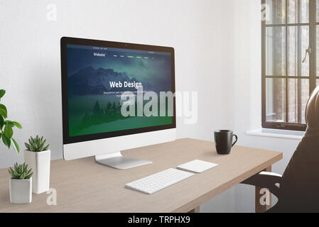 Web design studio office concept. Computer display with web presentation on desk. Keyboard, cup of coffee, plants beside. Stock Photo