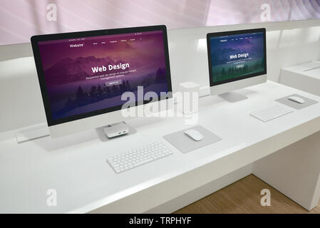 Web design development studio with two monitors and web site presentations. Stock Photo