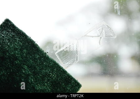 adhesive tape stain on window glass shield and scrub sponge Stock Photo
