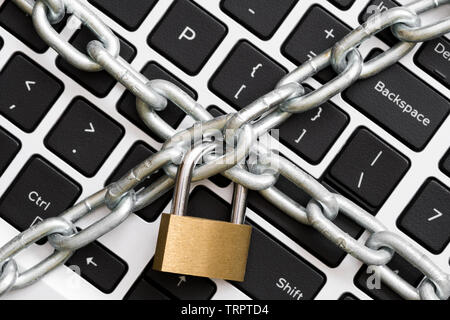 Cyber safety concept, locked chain on laptop computer keyboard Stock Photo