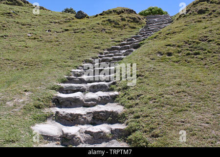 Stone steps cut into a grassy bank lead up the hillside to the summit.