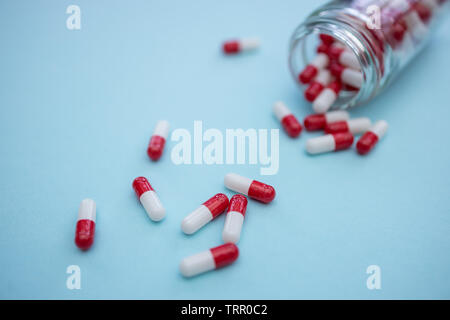 Drugs pills capsules on blue color background Stock Photo
