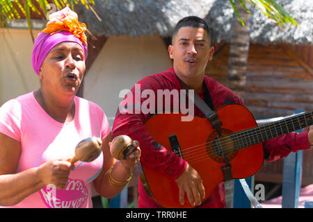 Male guitarist and female singer entertain tourists on Cayo Levisa (island) in the Los Colorados archipelago, Cuba, Caribbean Stock Photo