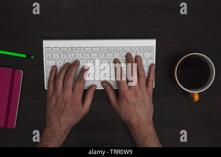 Man working computer keyboard on wood desk top view Stock Photo