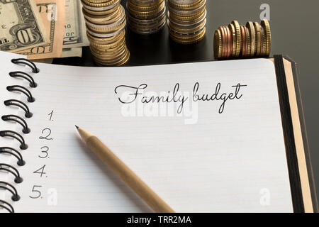 Family budget planning concept. Notepad with Family budget text, pencil and money on the background Stock Photo