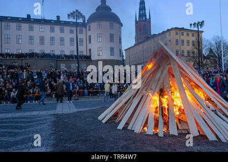 Burning wood pile and crowds in front of Wrangel Palace celebrating Mayday eve old custom (St. Walpurgis). Riddarholmen, Gamla Stan, Stockholm, Sweden Stock Photo
