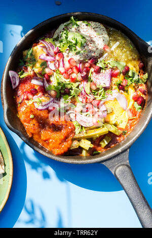 Shaksouka Hola Mexico. Eggs baked in aromatic tomato and peppers paste, with beans, served with marinated cactus, guacamole, salsa verde, salsa chipot Stock Photo