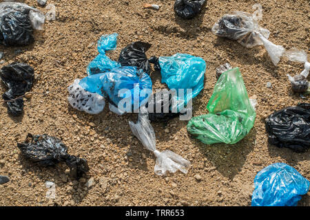 Close up of discarded colourful plastic dog poop bags in sandy public dog toilet area in city park Stock Photo Alamy