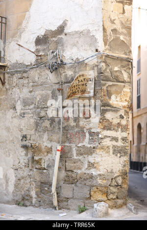 Detail of the corner of an old stone house with wiring and oldness of signboard in Palermo, Italy. Text: "Welding work Electric and gas welding.." Stock Photo