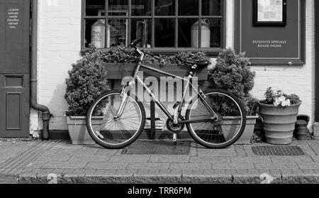 Bicycle propped up by window of old coaching inn Stock Photo