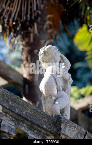 Italy Piedmont lakes area Stresa antique cupid sculpture on stone garden wall Stock Photo
