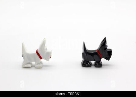 Two black and white dog plastic miniatures, isolated on white background, close-up Stock Photo