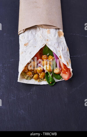 Vegan wraps in pita with chickpeas and mashed avocado on dark background Stock Photo