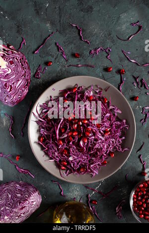 Red cabbage salad with pomegranate on dark background. Top view. Vegetarian and vegan food. Stock Photo