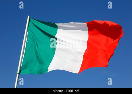 Close-up of the Italian national flag against a blue sky. Stock Photo