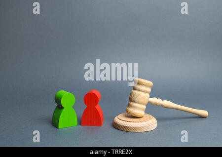 Two figures of people opponents stand near the judge's gavel. Conflict resolution in court, claimant and respondent. Court case, resolution and disput Stock Photo