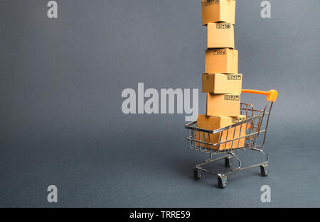 High tower of cardboard boxes on a supermarket trolley. concept of shopping in online store. E-commerce, sales and sale of goods through online tradin Stock Photo
