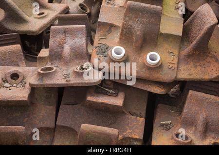 Pile of assorted spare rusty metal cast iron rail chairs ready for use to support railway line tracks chairs at Didcot Railway Centre, Oxfordshire, UK Stock Photo