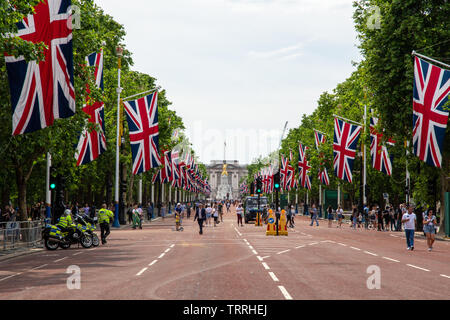 London, England, UK - June 1, 2019: Union Jack flags fly along The Mall ahead of a ceremonial event in central London, while crowds of tourists walk o Stock Photo