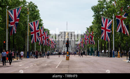 London, England, UK - June 1, 2019: Union Jack flags fly along The Mall ahead of a ceremonial event in central London, while crowds of tourists walk o Stock Photo