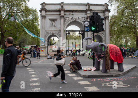 London, England, UK - April 23, 2019: Cyclists and pedestrians travel through a protest camp by Extinction Rebellion at Marble Arch in central London. Stock Photo